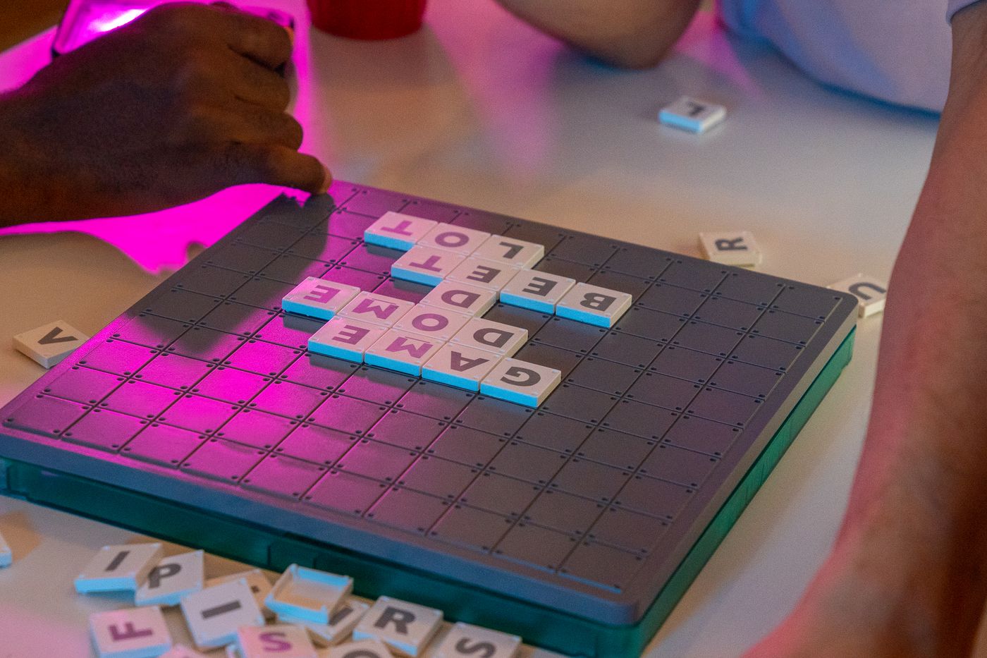 Friends making words with letter tiles on a board