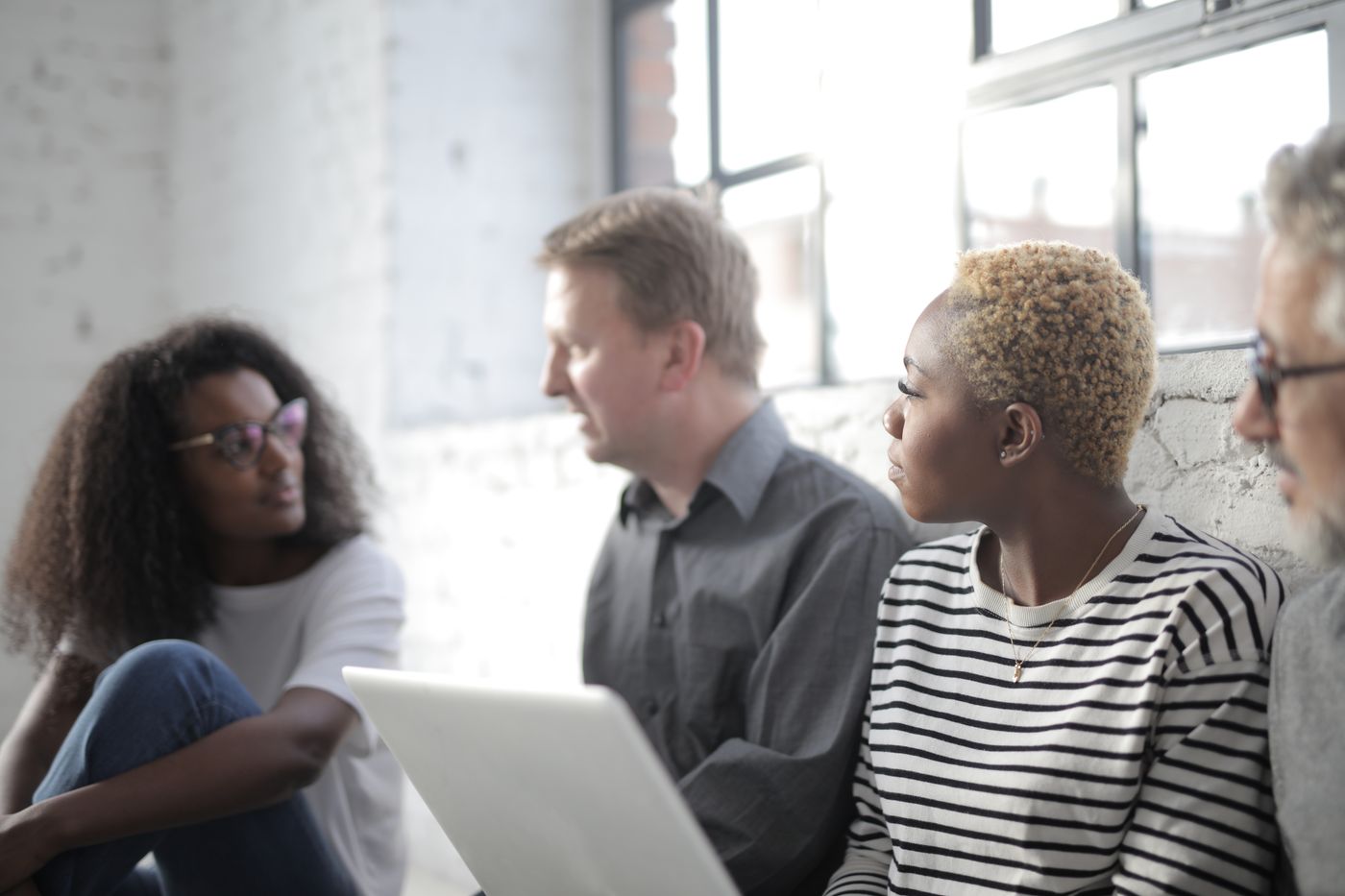 People talking together around a laptop